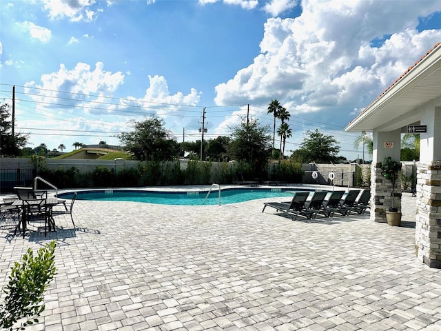 pool featuring fence and a patio