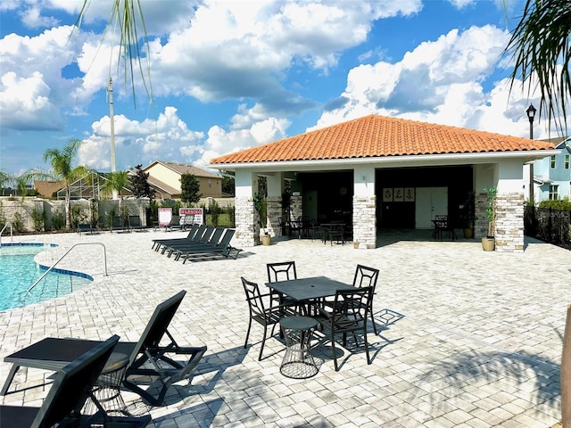 view of patio with a community pool and fence