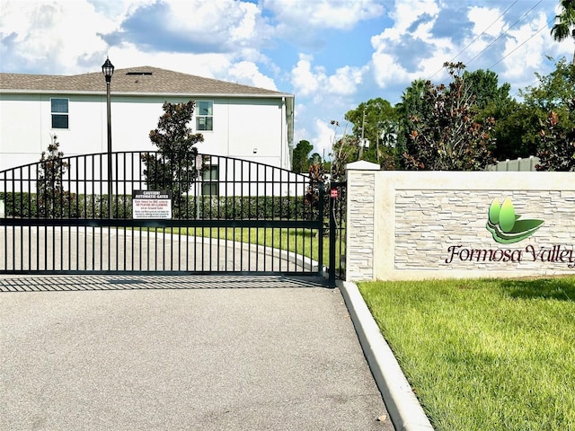 view of gate featuring a lawn and fence