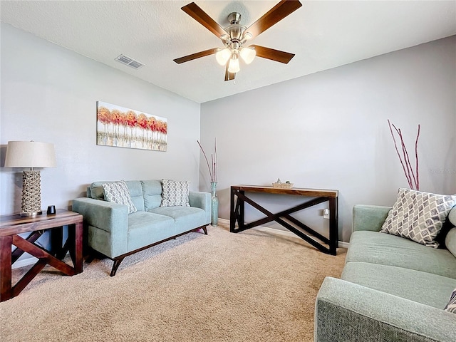 carpeted living room featuring a textured ceiling and ceiling fan