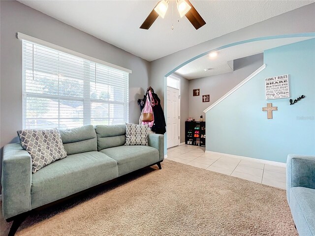 carpeted living room with ceiling fan