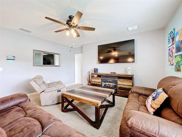 carpeted living room with a textured ceiling and ceiling fan