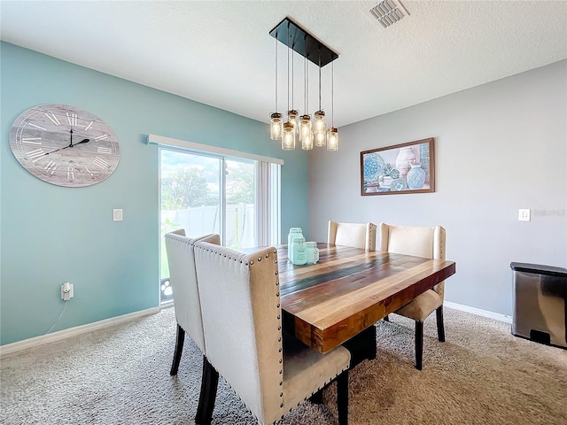 dining room with light colored carpet and a textured ceiling