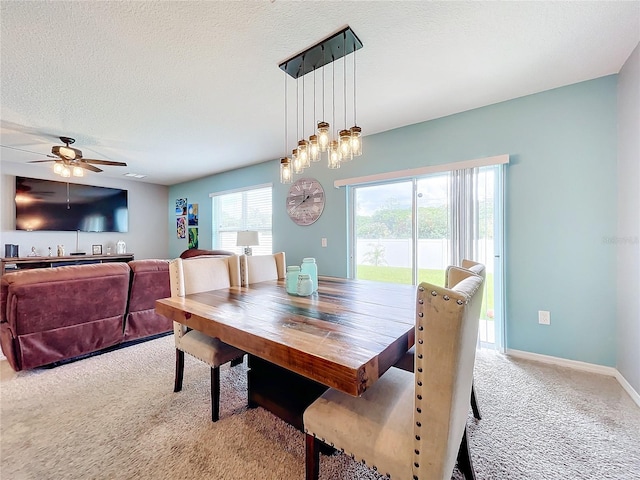 carpeted dining space with a textured ceiling and ceiling fan