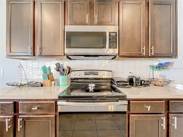 kitchen featuring tile patterned flooring, stainless steel appliances, and tasteful backsplash