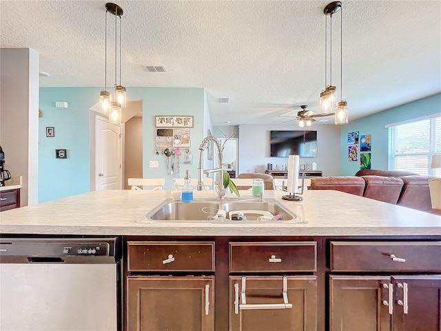 kitchen with a center island with sink, stainless steel dishwasher, sink, and ceiling fan