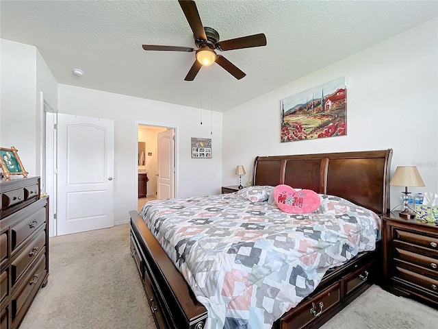 carpeted bedroom with ceiling fan, ensuite bathroom, and a textured ceiling