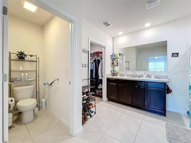 bathroom featuring a textured ceiling, tile patterned flooring, vanity, and toilet