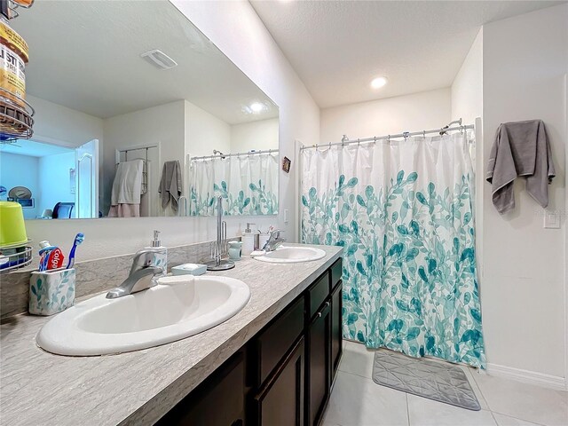 bathroom with a shower with shower curtain, vanity, and tile patterned floors