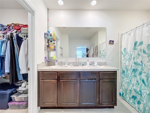 bathroom featuring walk in shower, tile patterned flooring, and vanity