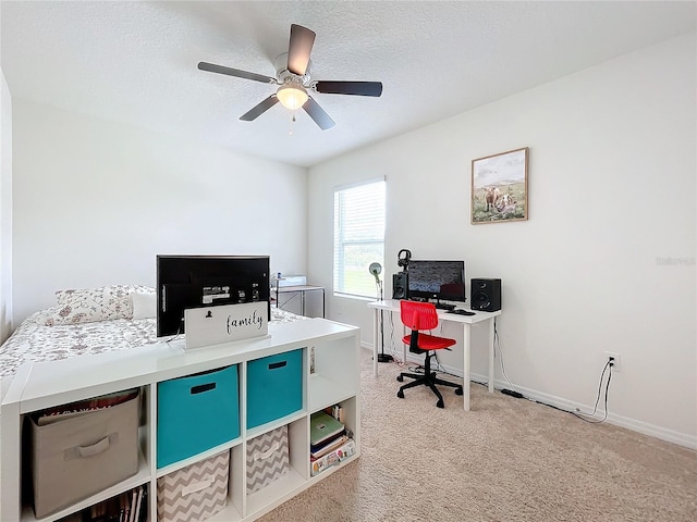 home office with a textured ceiling, carpet flooring, and ceiling fan