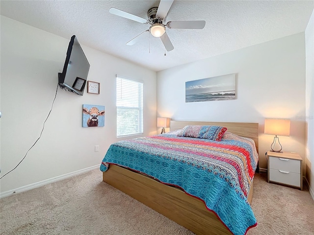 carpeted bedroom featuring ceiling fan and a textured ceiling