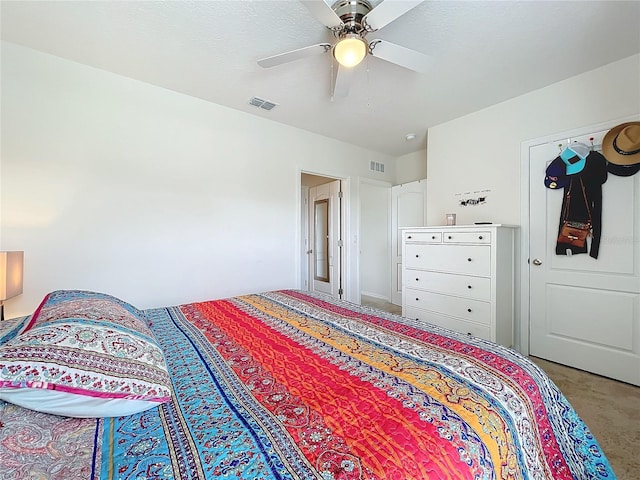 bedroom with ceiling fan, carpet flooring, and a textured ceiling