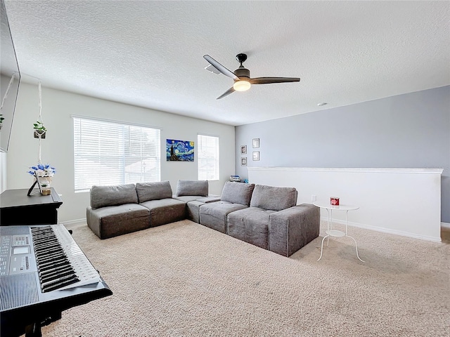 living room featuring light carpet, ceiling fan, and a textured ceiling