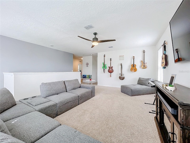 living room with ceiling fan, a textured ceiling, and carpet floors