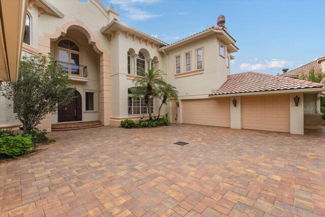 9164 Point Cypress Dr, Orlando, FL 32836 - mediterranean / spanish home featuring stucco siding, decorative driveway, a tile roof, and a balcony