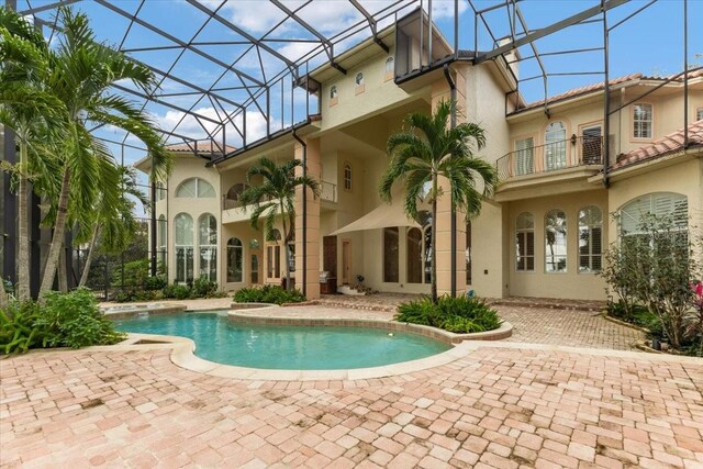 9164 Point Cypress Dr, Orlando, FL 32836 - back of property featuring a balcony, an outdoor pool, a patio, and stucco siding