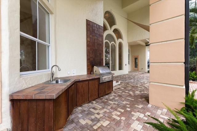 view of patio / terrace featuring a grill, area for grilling, and sink