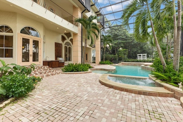 view of swimming pool featuring a lanai, a patio, a grill, and french doors