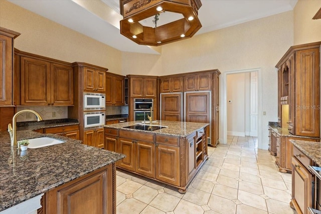 9164 Point Cypress Dr, Orlando, FL 32836 - kitchen featuring white microwave, a towering ceiling, brown cabinets, dark stone countertops, and tasteful backsplash