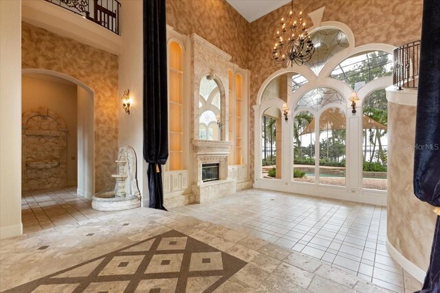 9164 Point Cypress Dr, Orlando, FL 32836 - unfurnished living room featuring a high ceiling, built in shelves, healthy amount of natural light, a chandelier, and a fireplace