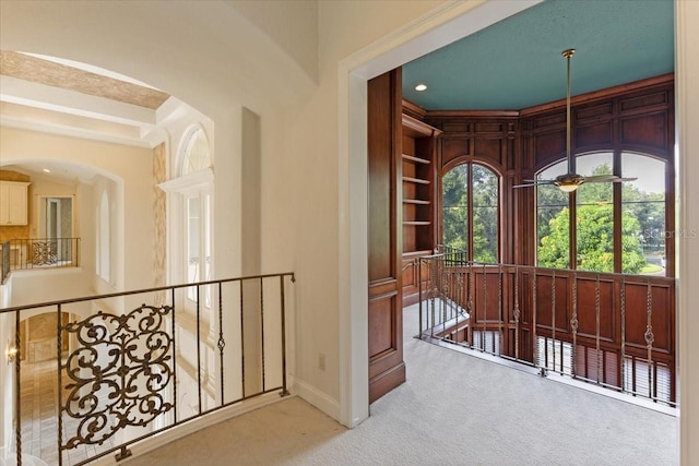 hall featuring built in shelves and carpet floors