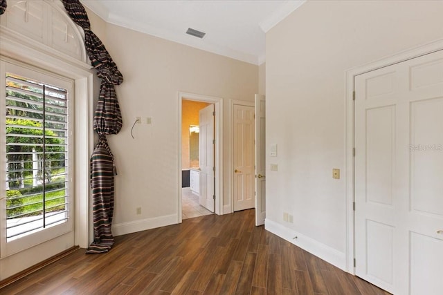 unfurnished bedroom featuring ornamental molding, dark hardwood / wood-style floors, and access to exterior