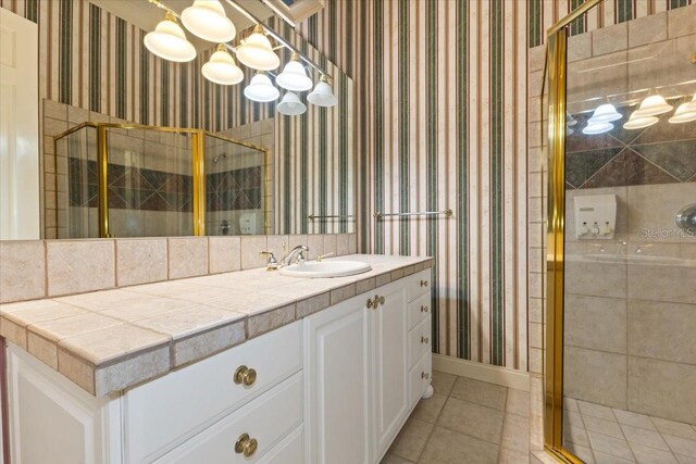 9164 Point Cypress Dr, Orlando, FL 32836 - bathroom with wallpapered walls, a shower stall, tile patterned flooring, and vanity