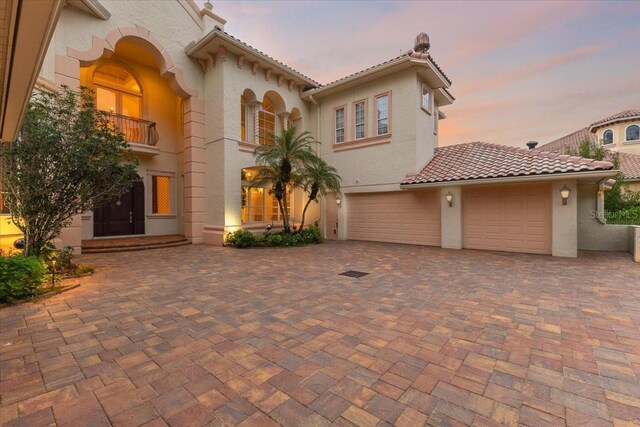 9164 Point Cypress Dr, Orlando, FL 32836 - mediterranean / spanish house featuring driveway, stucco siding, a balcony, and a tile roof