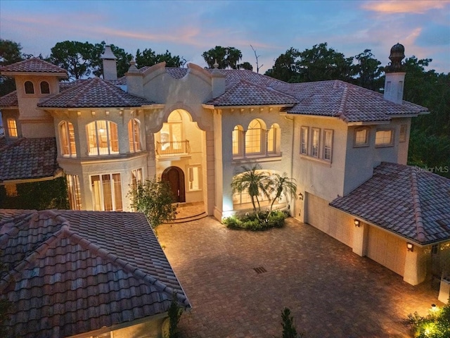 back house at dusk with a balcony