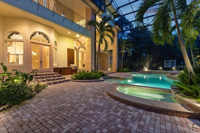 9164 Point Cypress Dr, Orlando, FL 32836 - view of swimming pool with french doors, glass enclosure, a pool with connected hot tub, and a patio