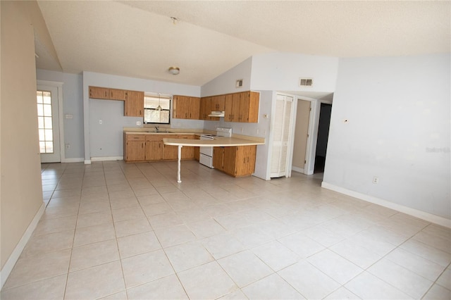 kitchen featuring white electric range oven, plenty of natural light, lofted ceiling, and sink