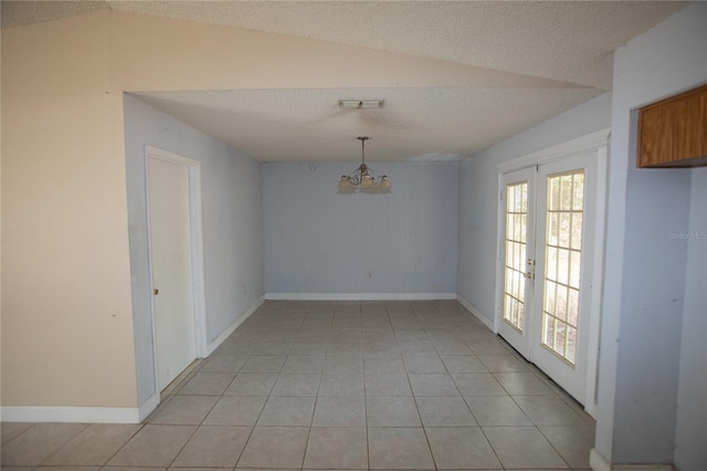 unfurnished dining area with french doors, a chandelier, vaulted ceiling, a textured ceiling, and light tile patterned floors