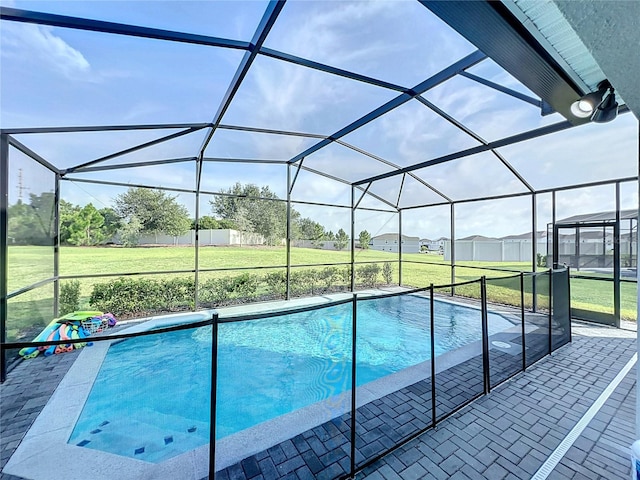 view of swimming pool featuring a lawn, a lanai, and a patio area