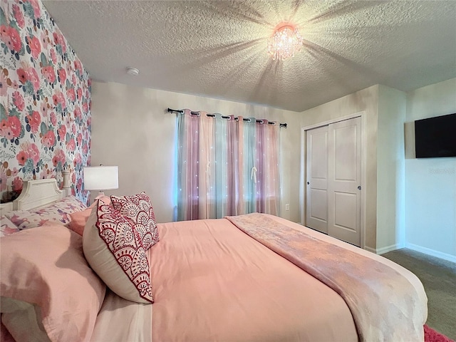 carpeted bedroom with a textured ceiling and a closet