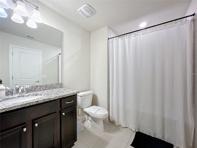 bathroom featuring curtained shower, tile patterned flooring, vanity, and toilet