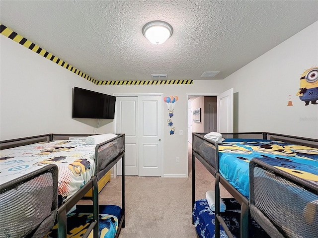 carpeted bedroom featuring a closet and a textured ceiling