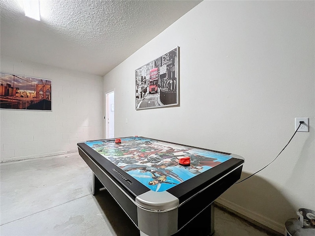 playroom with a textured ceiling and concrete floors