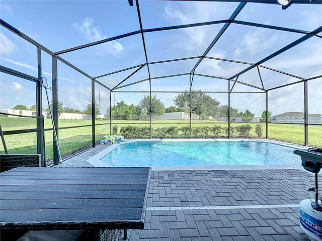 view of swimming pool with a patio, a yard, and a lanai