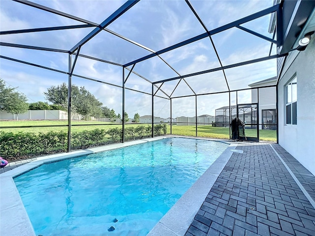 view of pool featuring glass enclosure, a patio, and a lawn