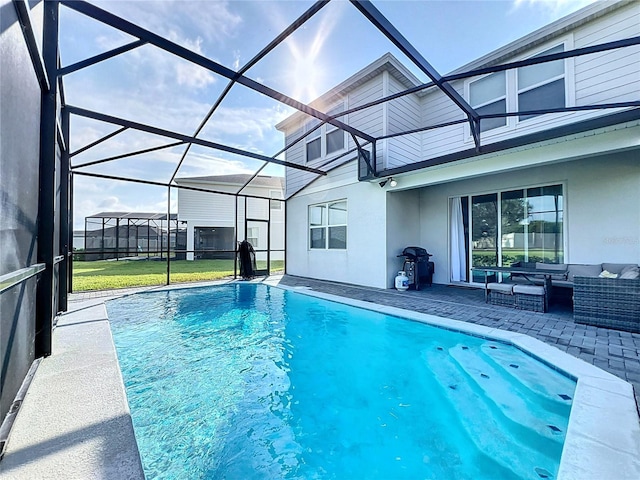 view of pool with area for grilling, a lanai, a patio area, and an outdoor hangout area