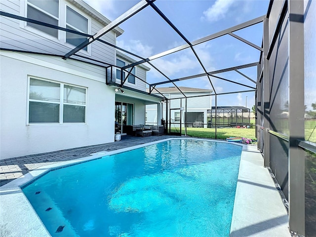 view of swimming pool featuring a lanai, an outdoor hangout area, a patio area, and a yard