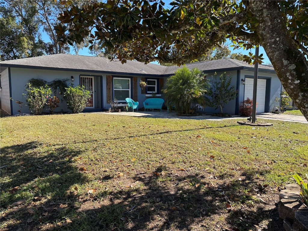 back of house featuring a garage and a yard