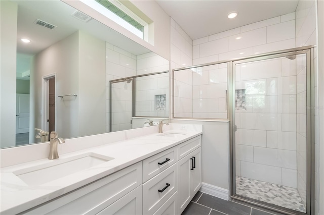 bathroom featuring visible vents, a sink, a stall shower, and double vanity