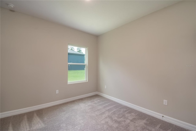 unfurnished room with carpet floors and baseboards