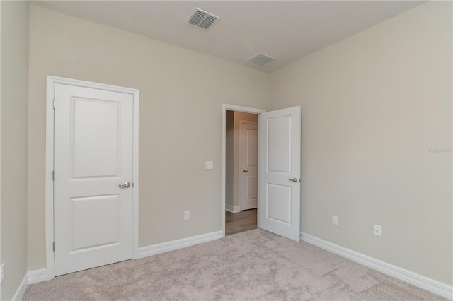 unfurnished bedroom featuring carpet flooring, baseboards, and visible vents