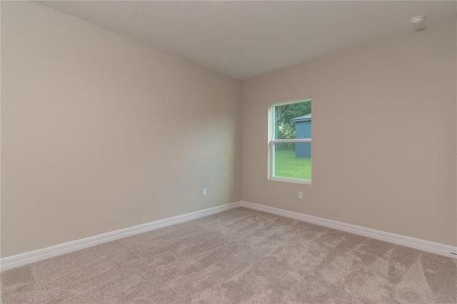 empty room with baseboards and light carpet