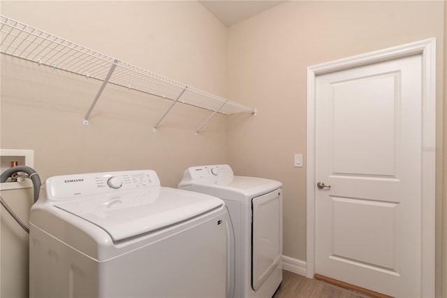 laundry room featuring baseboards, washer and dryer, light wood-style flooring, and laundry area