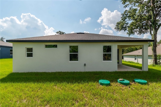 back of property featuring a lawn, stucco siding, and a patio
