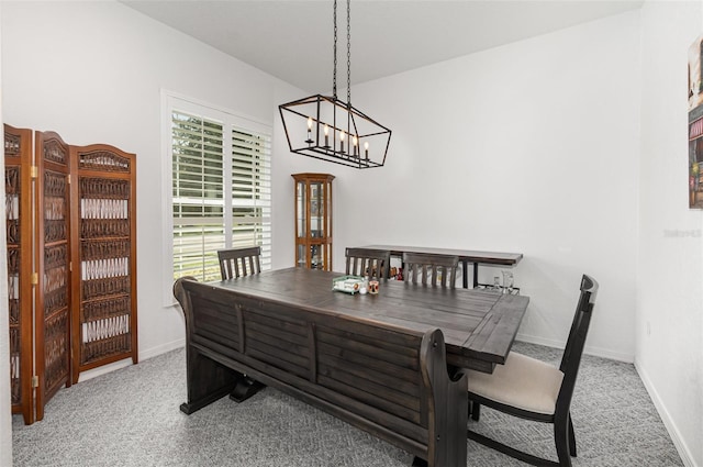 carpeted dining room featuring a notable chandelier